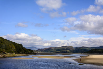 Scenic view of lake and mountains against cloudy sky at portmeirion