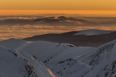 Aerial view of snowcapped mountains against sky during sunset, fagaras mountains