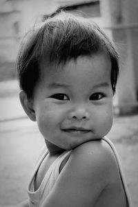 Close-up portrait of cute baby sitting outdoors