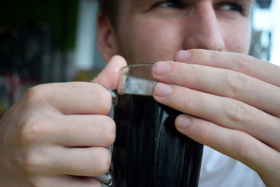 Close-up of man drinking black coffee at cafe