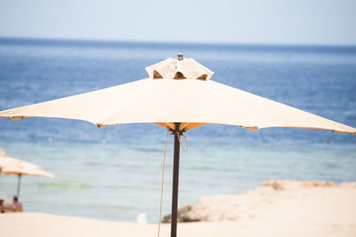 Umbrella on beach against sky