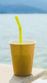 Close-up of drink on table by swimming pool