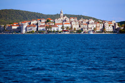 View of townscape by sea against sky