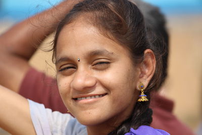 Close-up portrait of teenage girl smiling outdoors