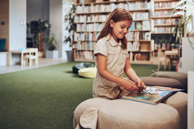 Student doing puzzle and reading book in school library. primary school child is involved in book