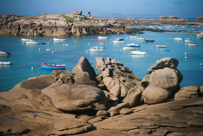 Sailboats on sea shore against sky