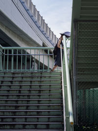 Low angle view of man on staircase against building