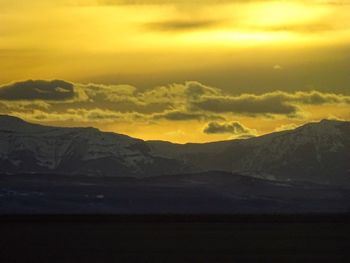 Scenic view of mountains against sky at sunset