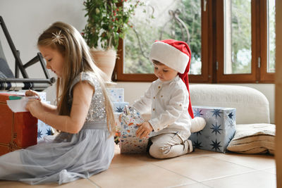 The brother and sister unwrapping christmas presents