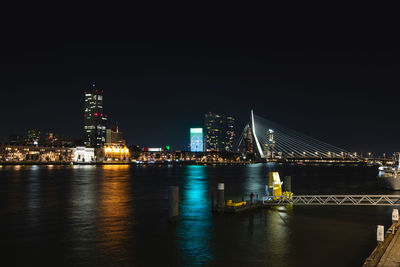 Illuminated bridge over river at night