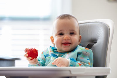 Portrait of cute baby girl sitting at home