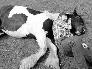 High angle view man hugging horse