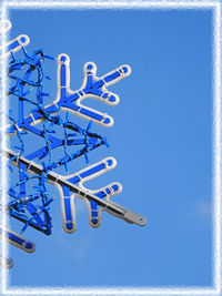 Low angle view of chain swing ride against clear blue sky