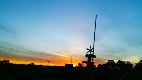 Low angle view of silhouette street light against sky at sunset