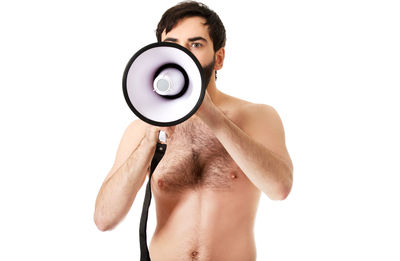 Portrait of shirtless man holding camera over white background