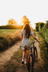 Rear view of woman riding bicycle on road