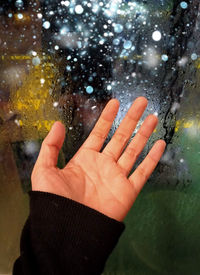 Hand of young woman at the window in the rain