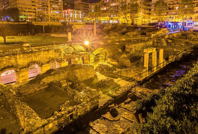 High angle view of illuminated street amidst buildings at night