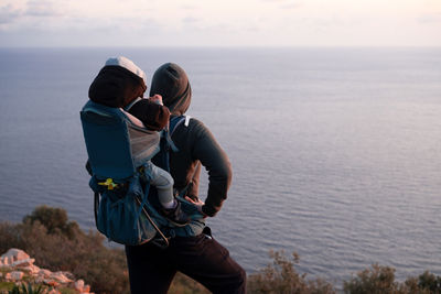 Rear view of woman photographing sea against sky