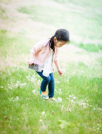 Full length of young woman walking on field