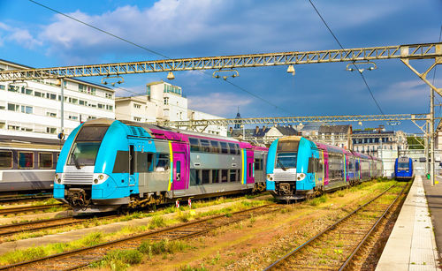 Train on railroad tracks in city against sky