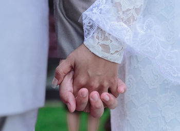 Midsection of couple holding hands