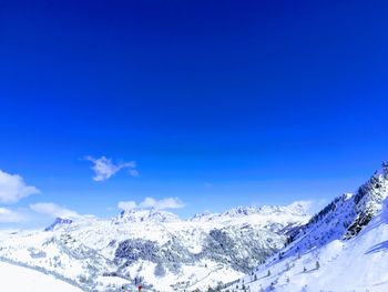 Scenic view of snowcapped mountains against blue sky