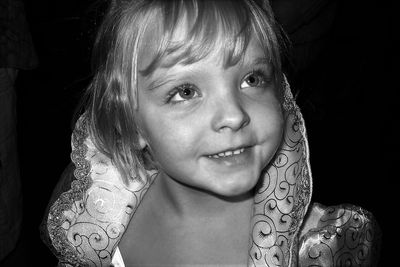 Close-up of cute girl wearing costume against black background