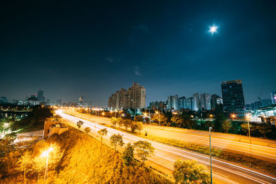 High angle view of light trails on highway in city at night