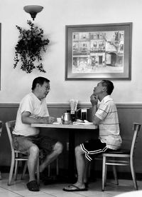 Man and woman sitting on table at home