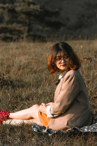 Portrait of woman sitting on field