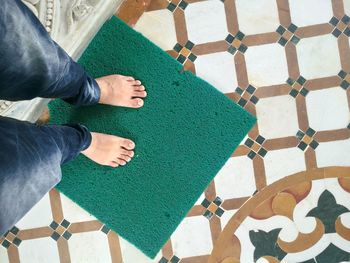 Low section of man standing on doormat in temple