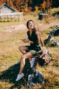 Full length of woman sitting on rock