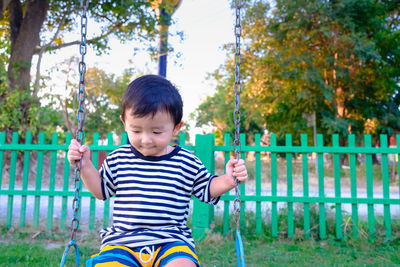 Boy playing with plants against fence