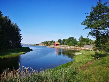 Scenic view of lake against clear blue sky