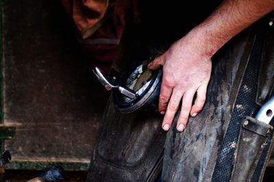 Cropped image of farrier making horseshoe in workshop
