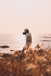 Full length of man on beach against sky during sunset