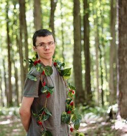 Portrait of young man standing in forest