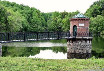 Footbridge leading stone house in lush