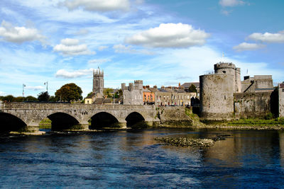 Arch bridge over river against buildings