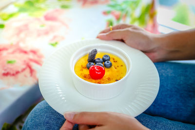 Midsection of man holding fruits in bowl