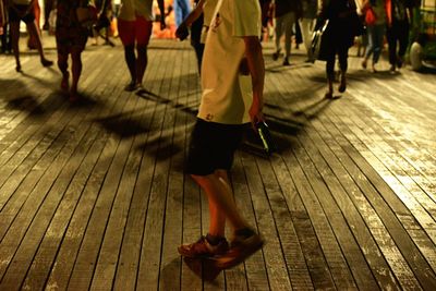 Low section of people walking on deck at night