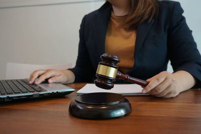 Midsection of woman using laptop on table