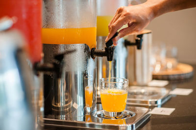 Cropped hand filling juice in glass