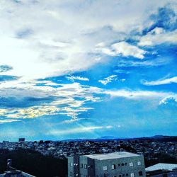 Aerial view of buildings against cloudy sky