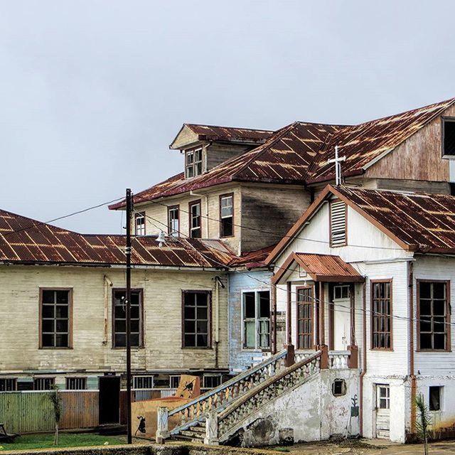 architecture, building exterior, built structure, house, residential building, residential structure, window, roof, sky, clear sky, building, low angle view, day, exterior, outdoors, no people, residential district, old, city, railing