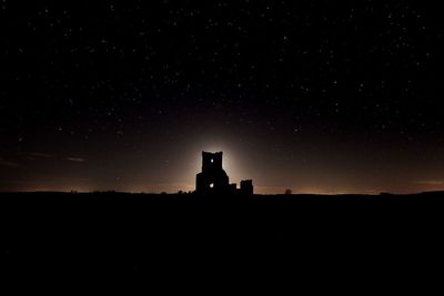 Silhouette building against sky at night