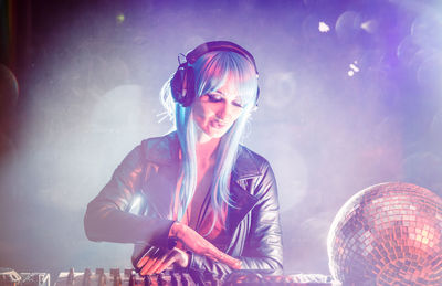 Woman playing dj at music concert