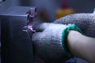 Cropped hands wearing gloves holding equipment