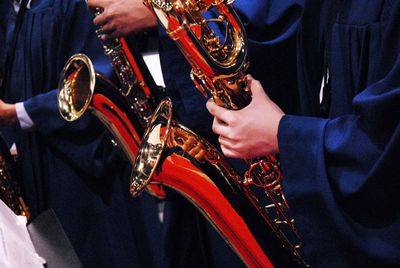 Midsection of musicians playing saxophones